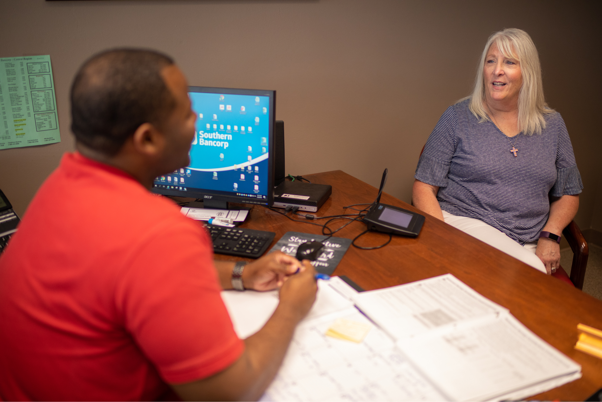 A bank employee helping a customer file taxes