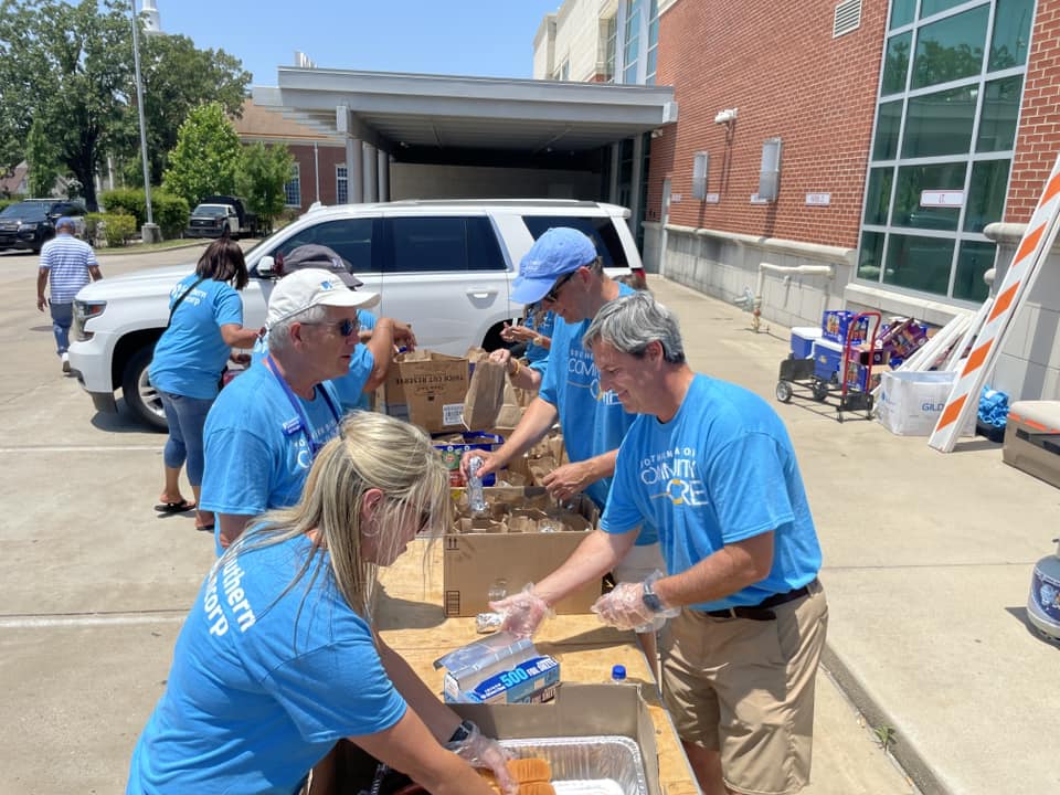 John y otros voluntarios del Núcleo Comunitario sirviendo comida en una celebración comunitaria de Little Rock.