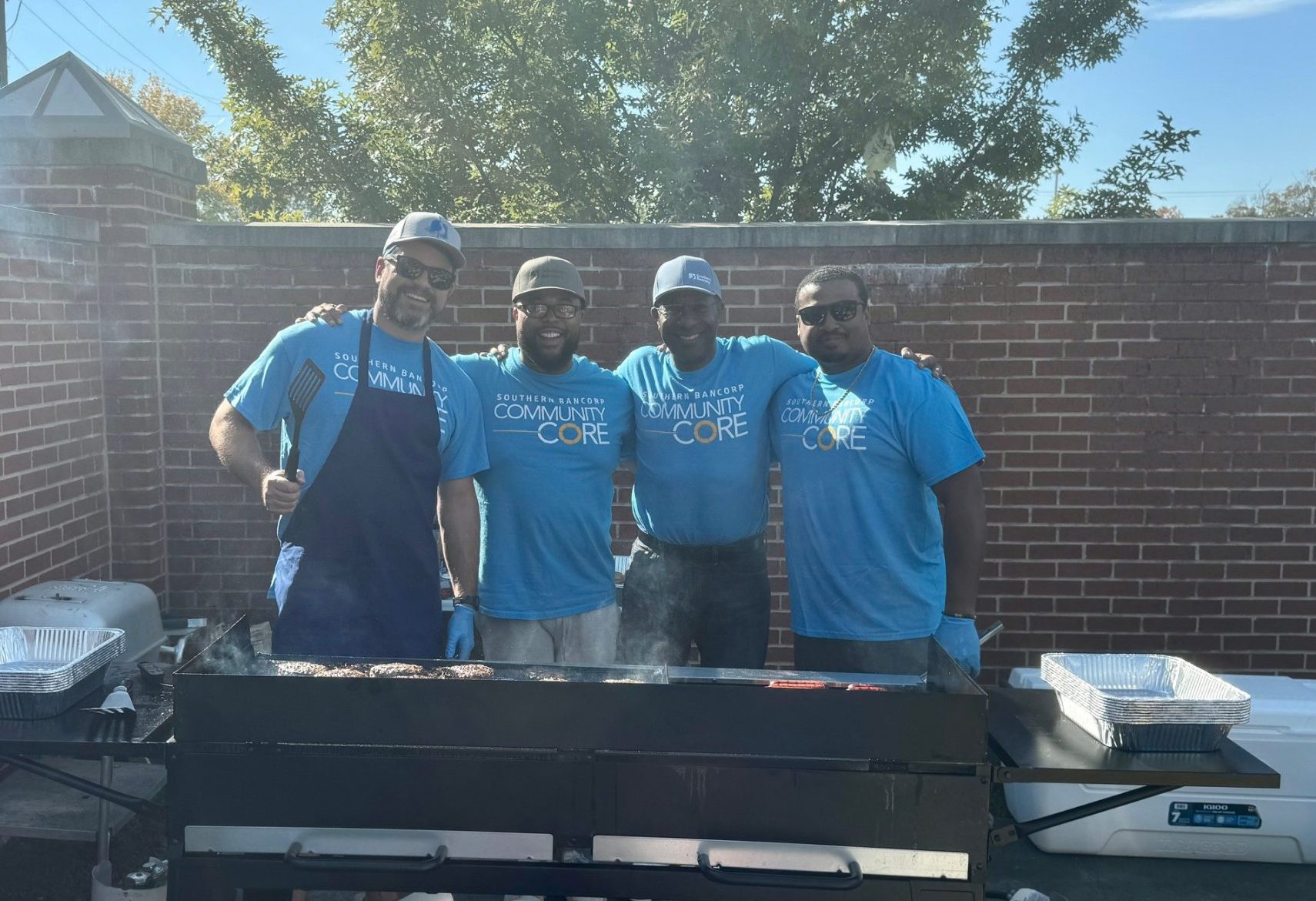 John y otros voluntarios del Núcleo Comunitario sirviendo comida en una celebración comunitaria de Little Rock.
